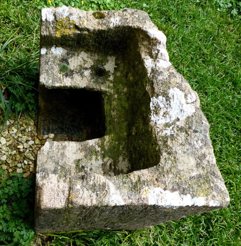 The head end of a medieval stone coffin found in the stones of the tower