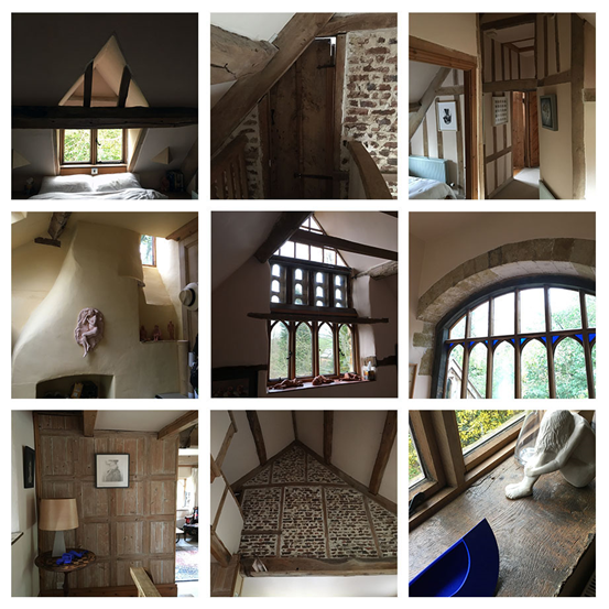 Attic room with a small triangular window, exposed wooden beams, and a sloped ceiling letting in light.